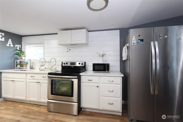 kitchen featuring sink, stainless steel appliances, light hardwood / wood-style floors, and white cabinetry