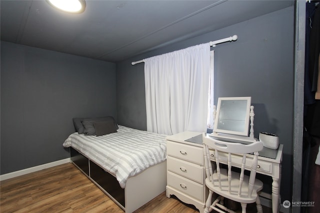 bedroom with dark wood-type flooring