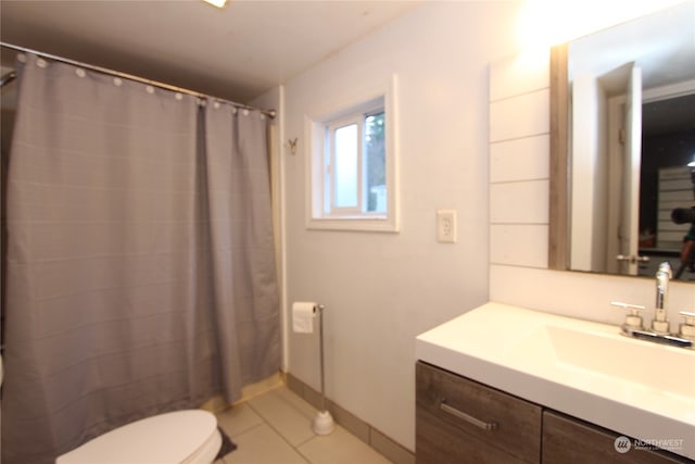 bathroom with walk in shower, vanity, toilet, and tile patterned floors