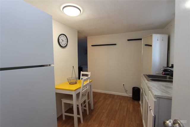 kitchen with wood-type flooring, white refrigerator, and sink