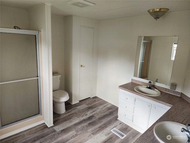 bathroom with vanity, hardwood / wood-style floors, toilet, and an enclosed shower