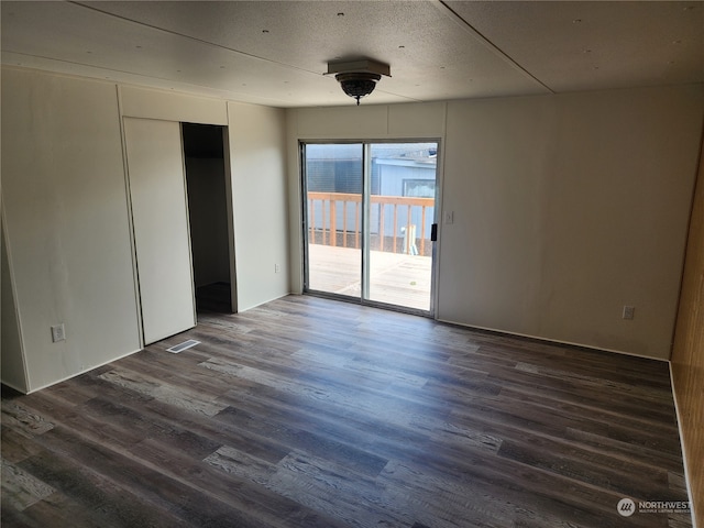 unfurnished room with dark wood-type flooring