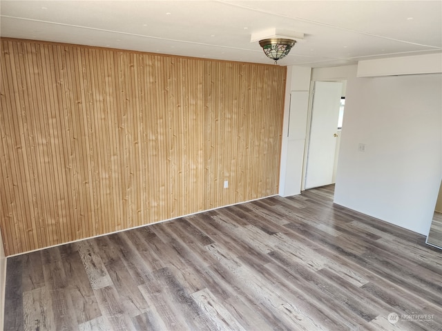 empty room with wood walls and hardwood / wood-style floors