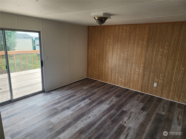 spare room with hardwood / wood-style flooring and wood walls