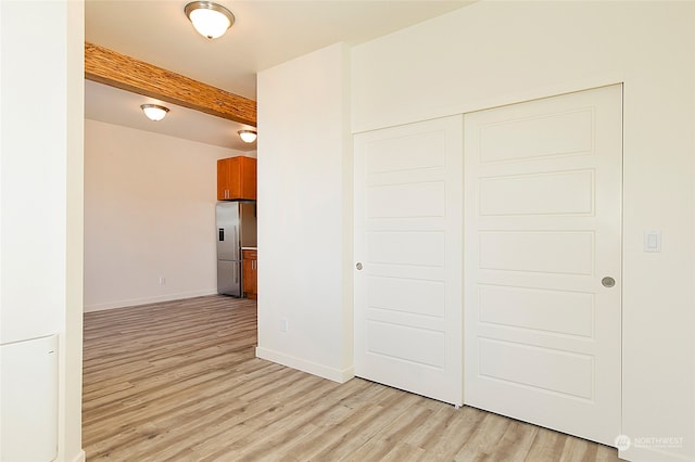 interior space with beamed ceiling and light hardwood / wood-style flooring