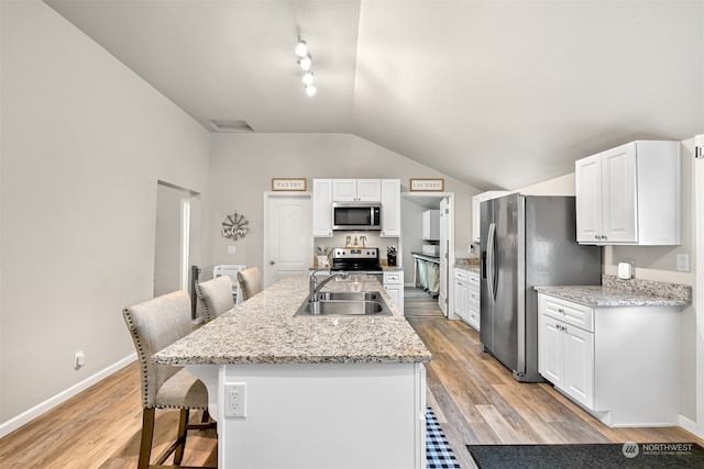 kitchen featuring a center island with sink, white cabinetry, light hardwood / wood-style flooring, sink, and stainless steel appliances