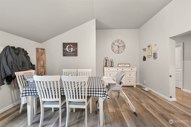 dining room with vaulted ceiling and hardwood / wood-style floors