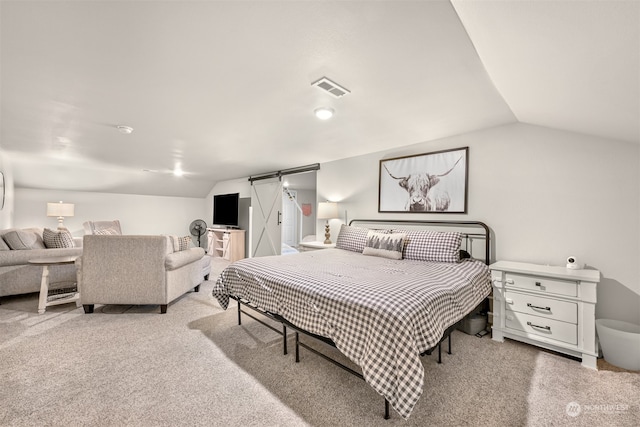 carpeted bedroom featuring lofted ceiling and a barn door