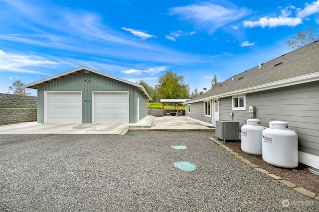 view of side of home featuring central air condition unit, an outbuilding, and a garage