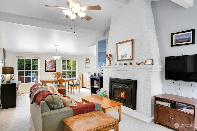 living room featuring lofted ceiling with beams, ceiling fan, light colored carpet, and a brick fireplace