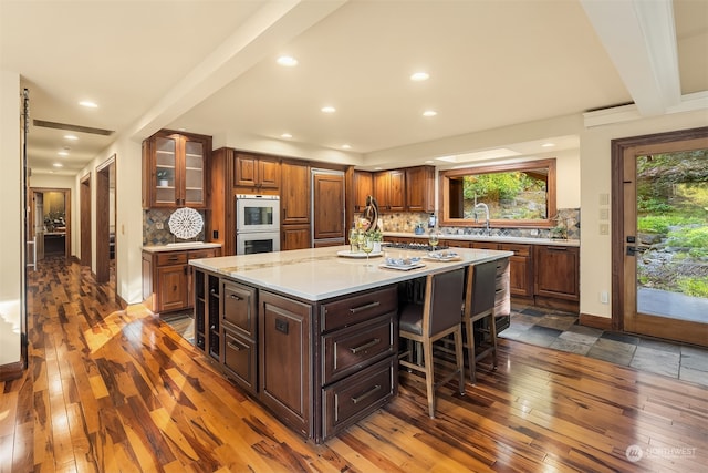 kitchen with a kitchen island, dark wood-type flooring, and a wealth of natural light