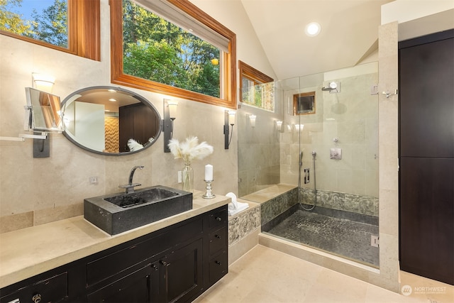 bathroom with vanity, lofted ceiling, an enclosed shower, and tile walls