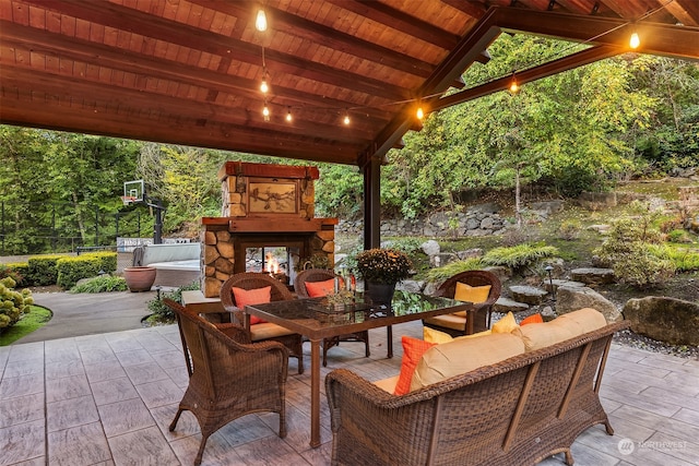 view of patio / terrace with an outdoor living space with a fireplace and a gazebo