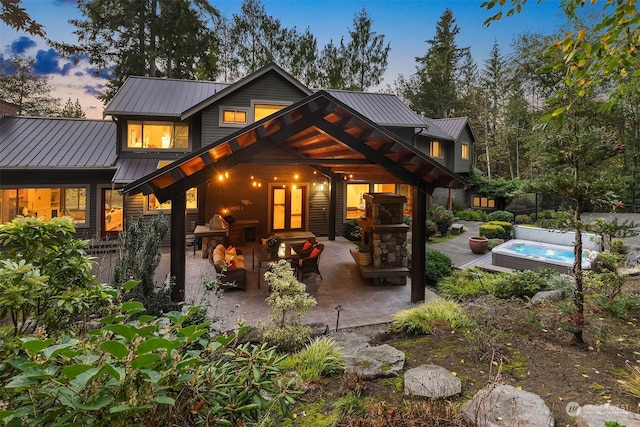 back house at dusk with a pool and a patio