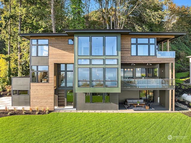 back of property featuring a balcony, a yard, and a patio area