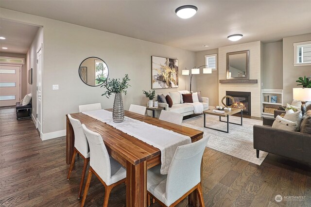 dining area featuring a fireplace and dark wood-type flooring