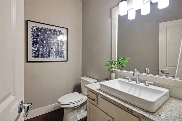 bathroom featuring wood-type flooring, vanity, and toilet