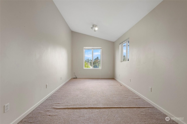 empty room with baseboards, light carpet, and lofted ceiling