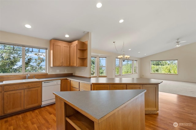 kitchen featuring a peninsula, open shelves, a healthy amount of sunlight, a sink, and white dishwasher