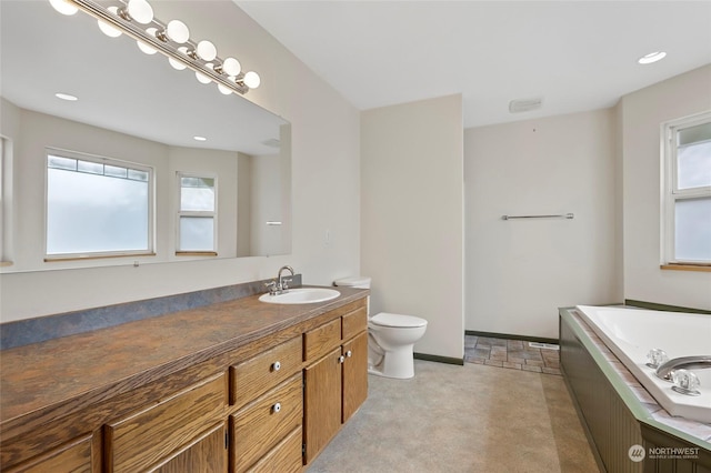 full bath featuring vanity, baseboards, a garden tub, and toilet