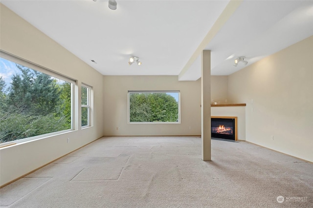 unfurnished living room with a fireplace with flush hearth, carpet flooring, and baseboards