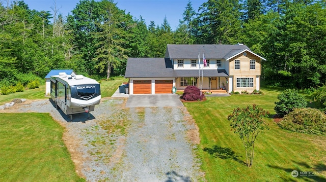 view of front of home with a garage, a front lawn, and covered porch