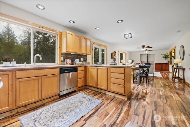 kitchen with light hardwood / wood-style floors, backsplash, light brown cabinets, ceiling fan, and stainless steel dishwasher