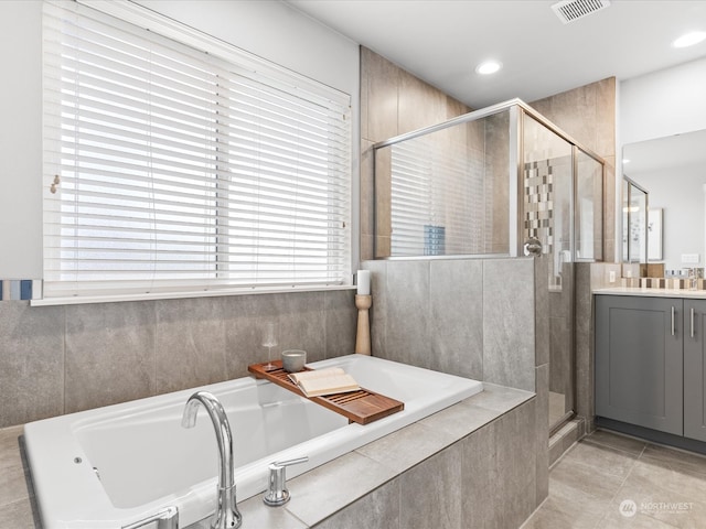 bathroom with shower with separate bathtub, vanity, and tile patterned floors