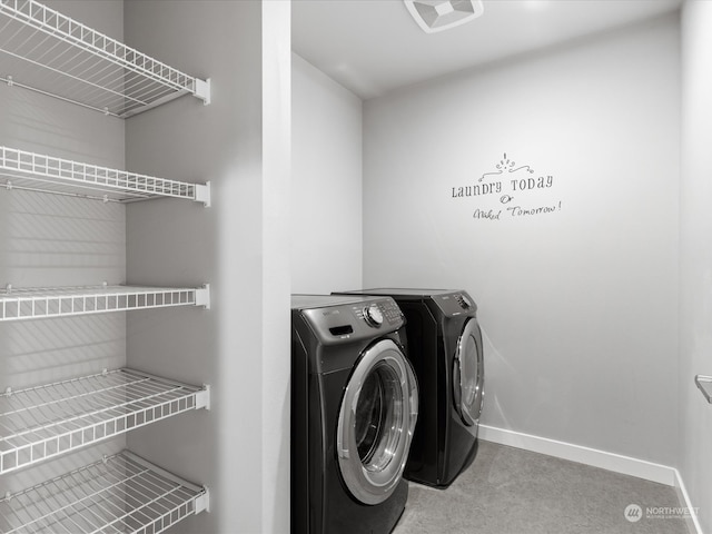 clothes washing area featuring light carpet and separate washer and dryer