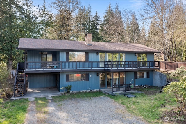 view of front of house featuring a wooden deck and a patio area