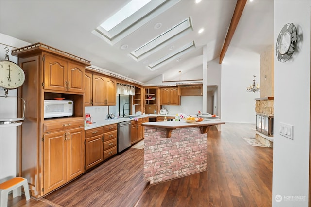 kitchen with vaulted ceiling with skylight, dark wood-type flooring, sink, a breakfast bar area, and stainless steel dishwasher