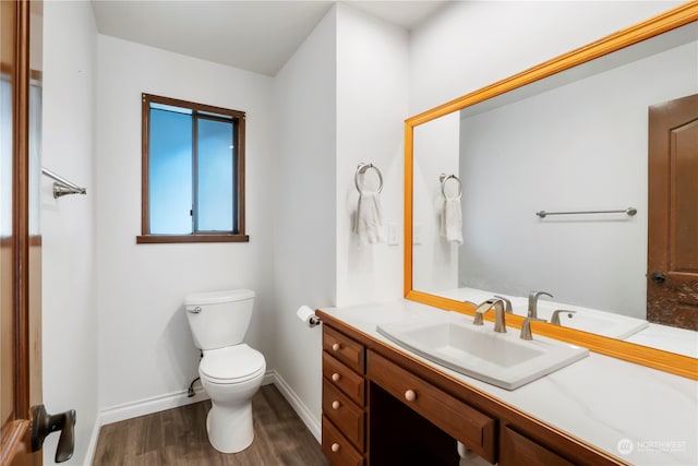 bathroom with wood-type flooring, vanity, and toilet