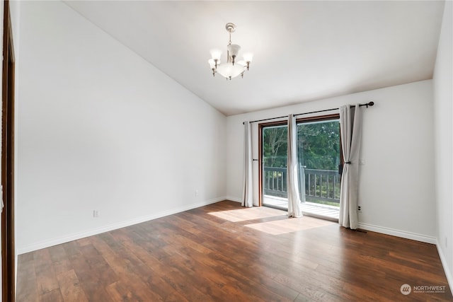 spare room featuring a chandelier, vaulted ceiling, and dark hardwood / wood-style flooring