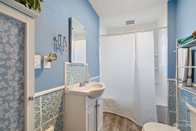 full bathroom featuring vanity, hardwood / wood-style floors, shower / bath combination with curtain, and toilet