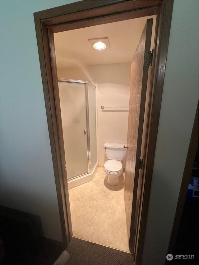 full bath featuring a shower stall and toilet