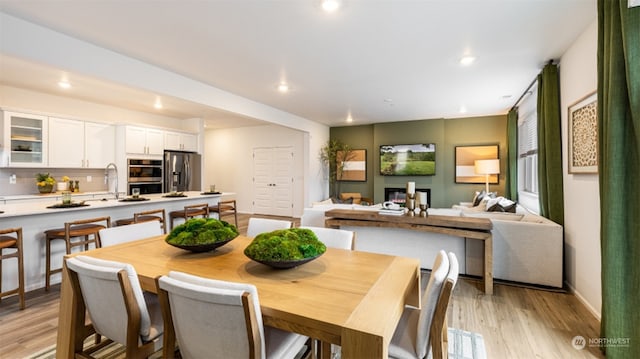 dining room with sink and light hardwood / wood-style floors