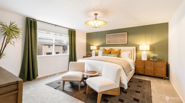 carpeted bedroom featuring an inviting chandelier