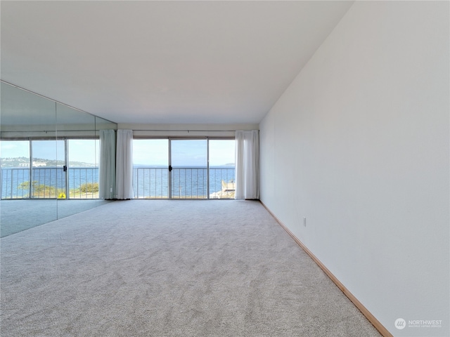 empty room featuring carpet and a water view