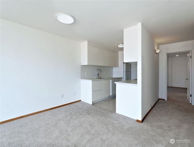 kitchen featuring light carpet, appliances with stainless steel finishes, tasteful backsplash, and white cabinetry