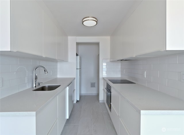 kitchen featuring black appliances, sink, and white cabinets