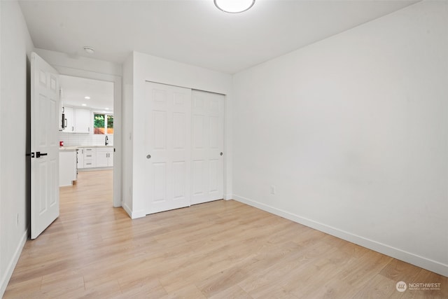 unfurnished bedroom with light wood-type flooring and a closet