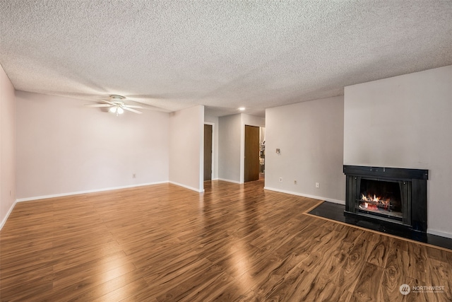 unfurnished living room with wood-type flooring, a textured ceiling, and ceiling fan