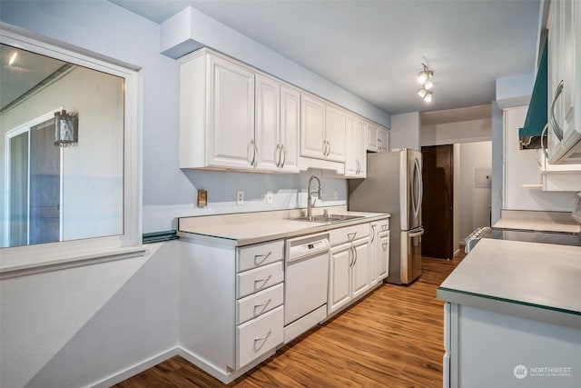 kitchen featuring light hardwood / wood-style floors, white cabinets, stainless steel refrigerator, dishwasher, and sink