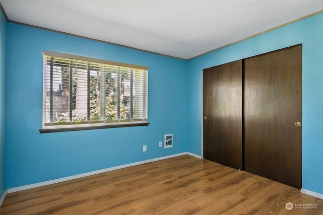 unfurnished bedroom with hardwood / wood-style floors and a closet