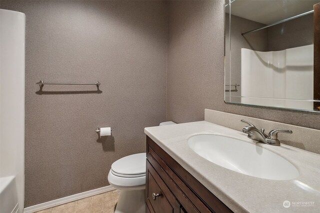 bathroom with walk in shower, vanity, and toilet