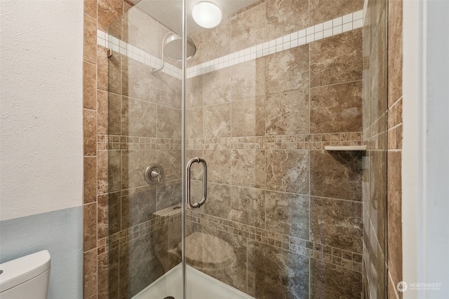 bathroom with toilet and an enclosed shower