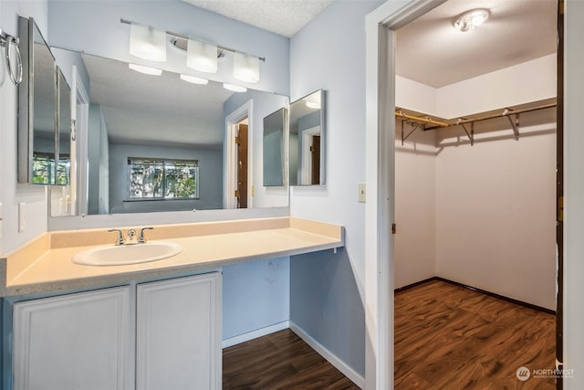 bathroom featuring wood-type flooring, a textured ceiling, and vanity