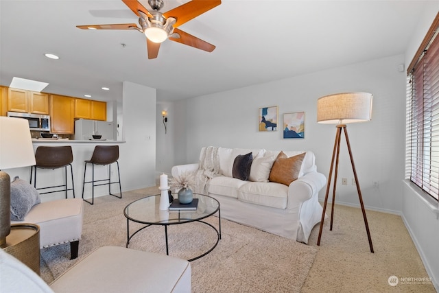 carpeted living room featuring ceiling fan