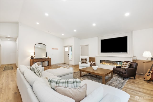 living room with light hardwood / wood-style floors and lofted ceiling