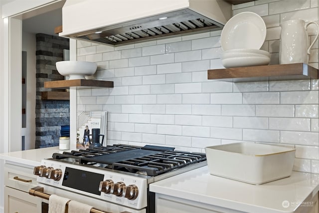 kitchen with white cabinets, white range, tasteful backsplash, and custom exhaust hood